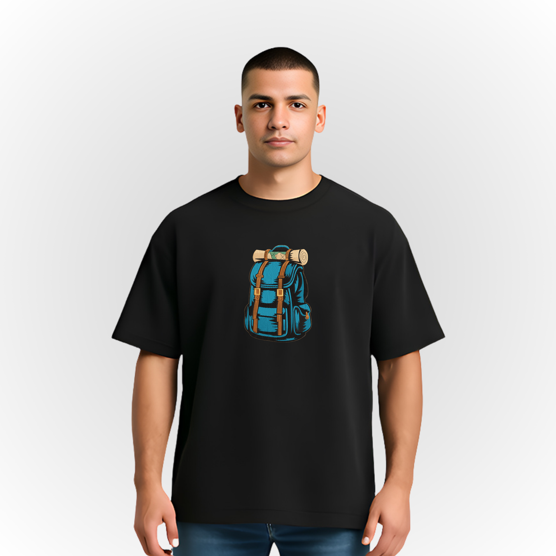 Person wearing a black t-shirt with a blue backpack embroidery on a plain background