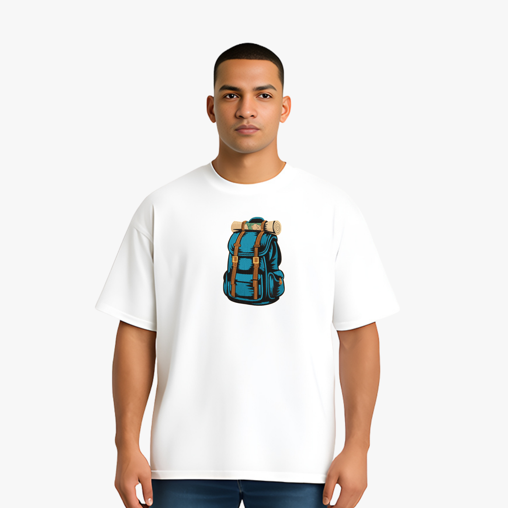 Person wearing a white t-shirt with a blue backpack embroidery on a plain background