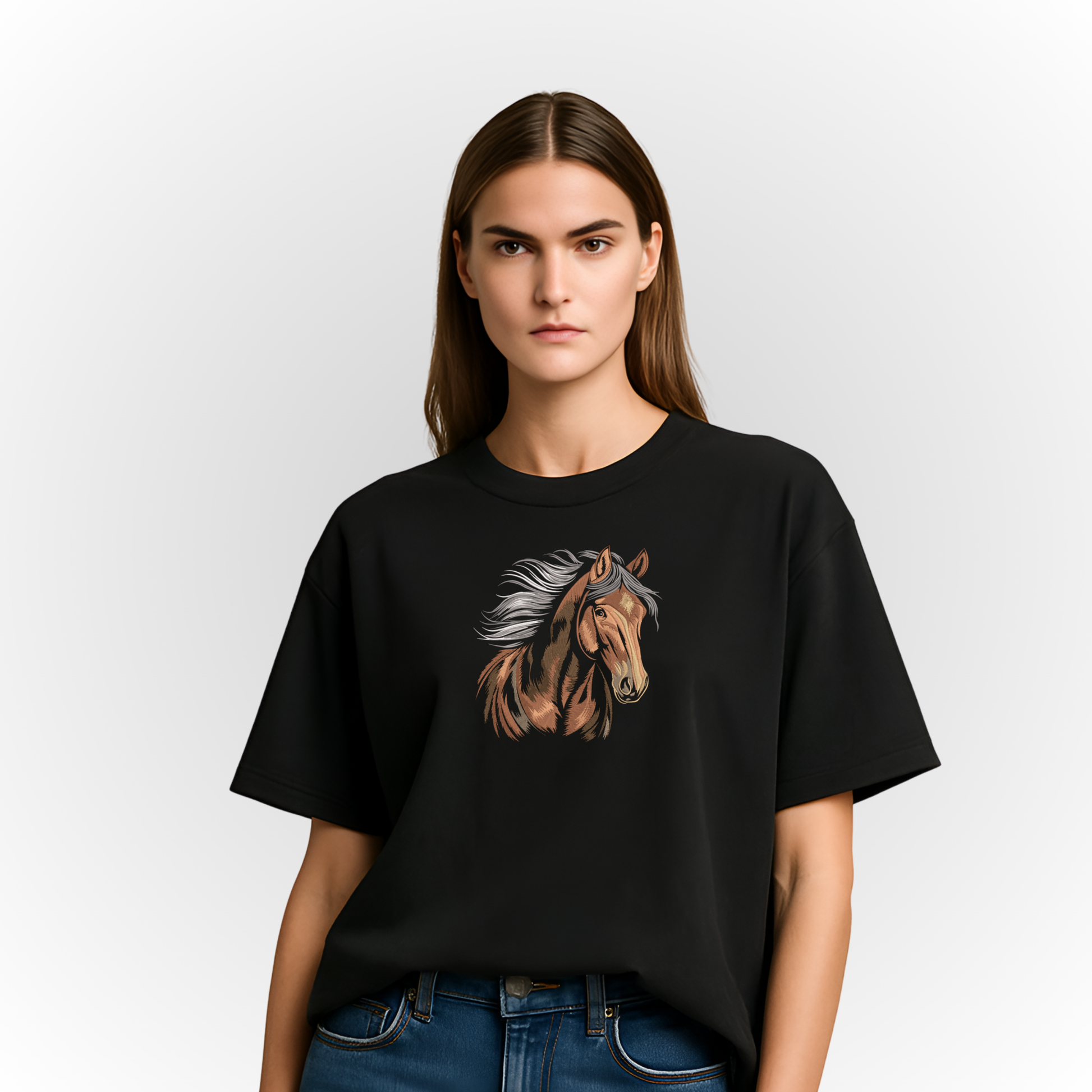 Person wearing a black t-shirt with a majestic horse embroidery on a plain background